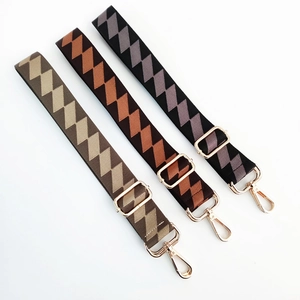 Detail of adjustable wide shoulder straps with geometric patterns and gold metal buckles