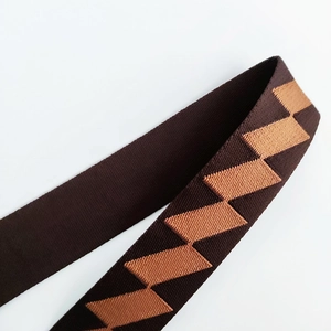 Close-up of durable woven shoulder strap featuring orange and brown geometric patterns