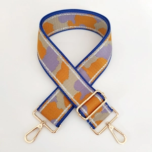 Detail view of thickened camo shoulder strap with gold metal lobster clasps and buckles