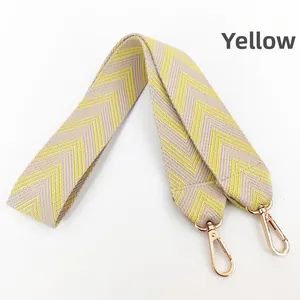 Close-up of wide yellow chevron jacquard strap with rose gold metal lobster clasps