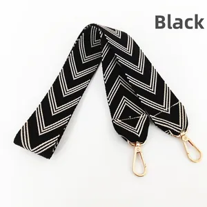 Detail of black and white chevron embroidered bag strap with gold metal hooks