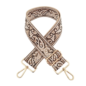 Close-up of ethnic paisley embroidered bag strap with gold metal hooks and buckle