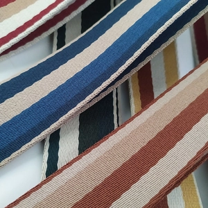 Macro shot of thick multi-color striped woven straps showing dense fabric texture