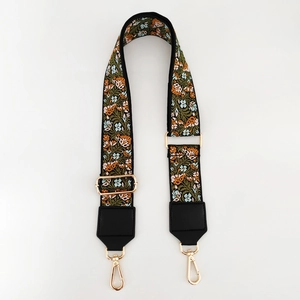 Close-up of floral embroidery jacquard strap with gold metal hardware for handbags