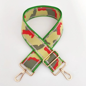 Detail of adjustable camouflage bag strap with gold metal buckles and woven texture