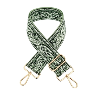 Close-up of ethnic paisley embroidered bag strap with gold lobster clasps and buckles