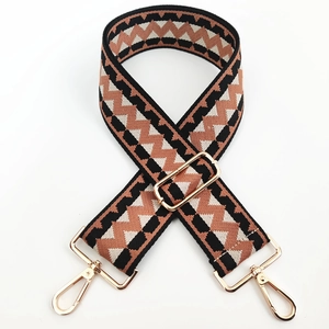 Detail of adjustable wide canvas shoulder strap with wave pattern and gold metal hooks