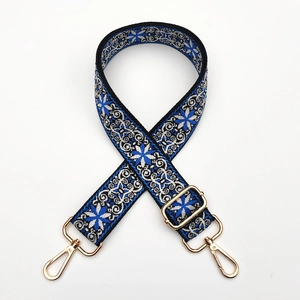 Detail of blue and white ethnic floral embroidery on a thick crossbody bag strap