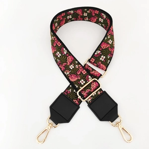 Detail of floral embroidery on wide ethnic strap with gold hooks and leather reinforcement