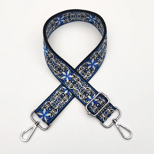Close-up of ethnic jacquard bag strap with blue floral pattern and silver metal clasps