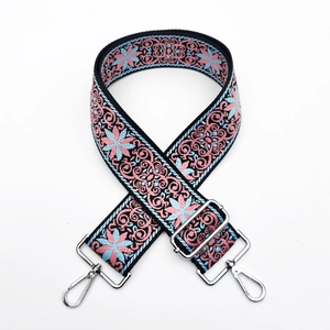 Detail of floral embroidery on wide adjustable bag strap with silver metal swivel hooks