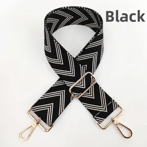 Close-up of black and white geometric woven shoulder strap with gold metal hooks