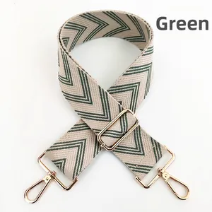 Close-up of green V-pattern woven shoulder strap with polished gold metal hardware