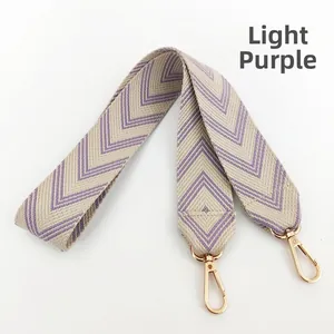Detail of light purple jacquard woven shoulder strap with gold metal carabiner hooks