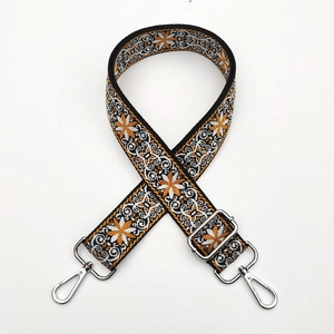 Detail of adjustable ethnic embroidery strap with silver metal lobster clasps on white base
