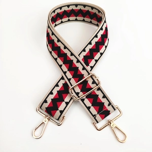 Adjustable wide canvas shoulder strap with red and black zigzag pattern and gold hardware