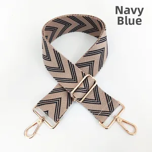 Detail of adjustable navy blue woven bag strap with golden hardware hooks and V-patterns