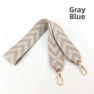 Close-up of thick grey blue chevron woven bag strap with golden metal swivel hooks