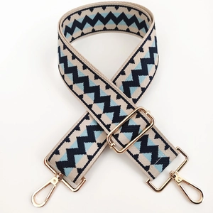 Adjustable wide canvas shoulder strap with navy geometric weave and gold metal hooks
