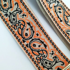 Detailed macro view of embroidered paisley pattern on a thick bohemian canvas bag strap