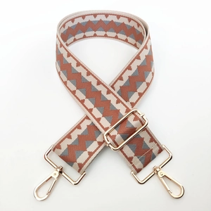 Detail of wide adjustable chevron woven strap with gold metal lobster clasps for handbags