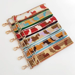 Detail of adjustable camouflage jacquard bag straps with golden metal lobster clasps