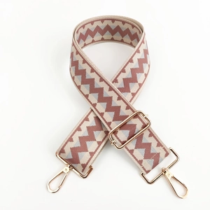Close-up of zigzag woven bag strap with golden metal swivel hooks and adjuster