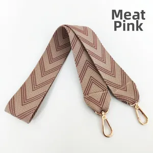 Detail of dusty rose jacquard embroidered bag strap with golden lobster clasp hooks