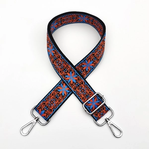 Detail of adjustable ethnic embroidered bag strap with floral patterns and silver hooks