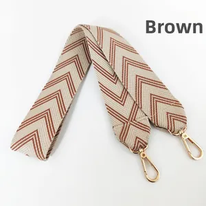 Detail of wide brown chevron jacquard guitar strap with golden metal spring hooks