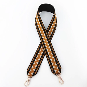 Close-up of geometric pattern wide strap with polished golden lobster clasps