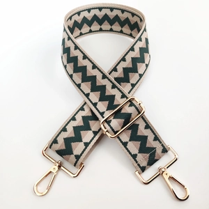Detail of adjustable woven canvas bag strap with green geometric zigzag patterns