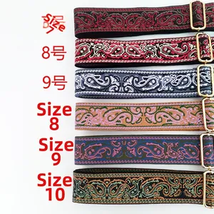 Detailed embroidery texture of paisley patterned bag straps with gold metal buckles