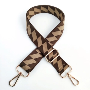 Detail of adjustable wide shoulder strap with beige and brown geometric weave pattern
