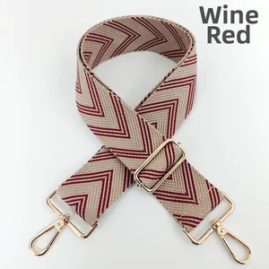 Detail of wine red braided bag strap with V-shaped texture and gold metal lobster clasps