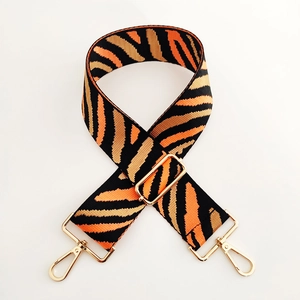 Close-up of wide zebra-pattern strap with high-density weave and gold lobster clasps