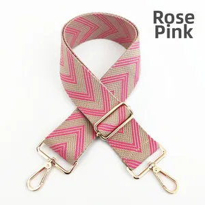 Detail of rose pink and beige woven adjustable bag strap with golden metal swivel hooks