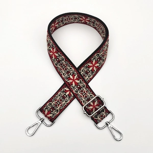 Detailed close-up of ethnic jacquard embroidery purse strap with silver metal lobster clasps
