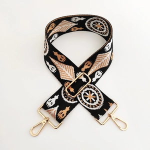 Détail de la bandoulière tissée style ethnique avec motifs géométriques et boucles dorées