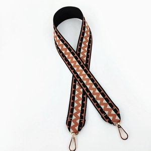 Close-up of ethnic geometric wavy pattern on woven wide replacement shoulder strap with gold clips