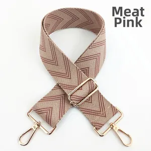 Detail of nude pink woven replacement bag strap with chevron pattern and gold metal hooks
