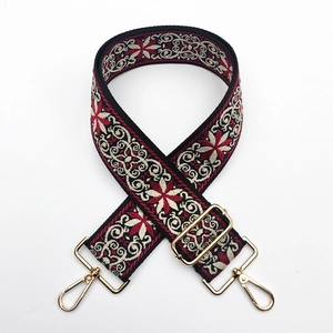 Close-up of bohemian embroidered bag strap with gold metal lobster hooks and slider