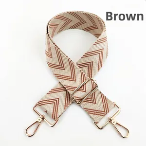 Detail view of woven brown and beige bohemian bag strap with gold metal buckles