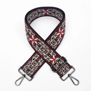Detail of 5cm wide thick jacquard bag strap with ethnic floral pattern and gun-black metal buckle