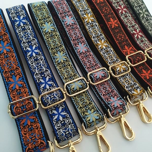 Close-up of ethnic embroidered bag straps with colorful jacquard and gold metal hooks