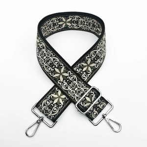 Detailed view of adjustable ethnic embroidered shoulder strap with silver metal hooks