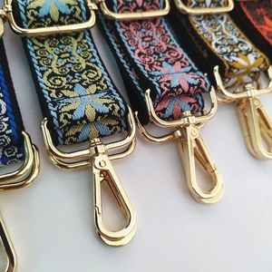 Close-up of ethnic floral jacquard bag straps with golden metal swivel hooks