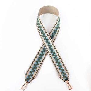 Detail of geometric wave woven bag strap in beige and blue with gold lobster clasps