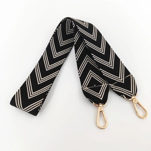 Close-up of black and white chevron woven bag strap with premium gold metal swivels