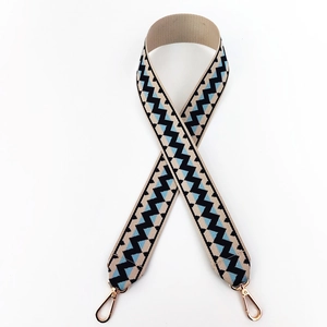 Close-up of ethnic wavy pattern woven shoulder strap with gold metal lobster clasps